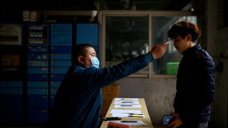 Un trabajador controla la temperatura en una fábrica de Zhejiang en Wenzhou el 27 de febrero de 2020. (NOEL CELIS/AFP vía Getty Images)