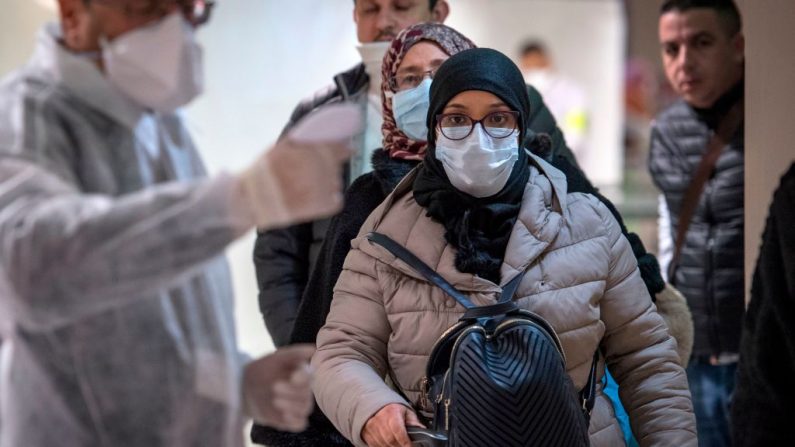 Trabajadores sanitarios marroquíes escanean a los pasajeros que llegan de Italia para detectar el coronavirus COVID-19 en el aeropuerto internacional Mohammed V de Casablanca el 3 de marzo de 2020. (Foto de FADEL SENNA/AFP vía Getty Images)
