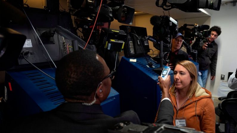 Un médico comprueba las temperaturas de periodistas en una Sala de Prensa. (Foto ilustrativa de JIM WATSON/AFP vía Getty Images)

