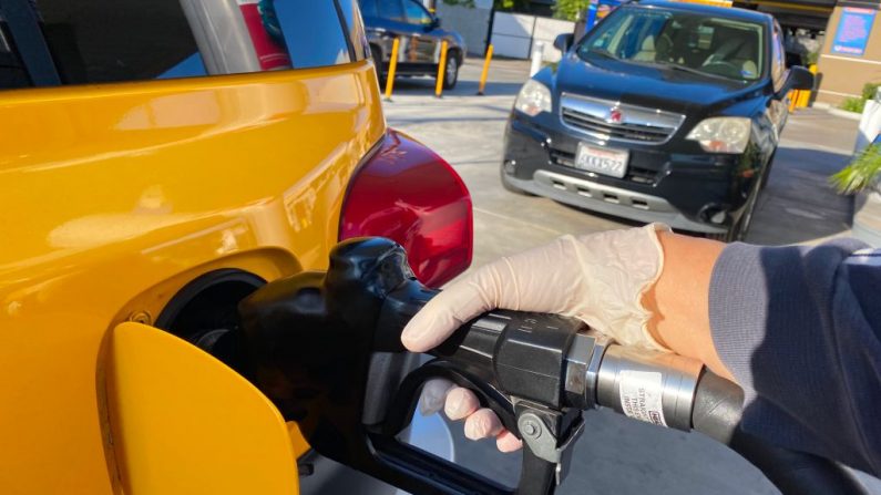 Una mujer usa un guante como medida preventiva contra el coronavirus, Covid-19, en una gasolinera de Los Ángeles el 18 de marzo de 2020. (CHRIS DELMAS/AFP vía Getty Images)