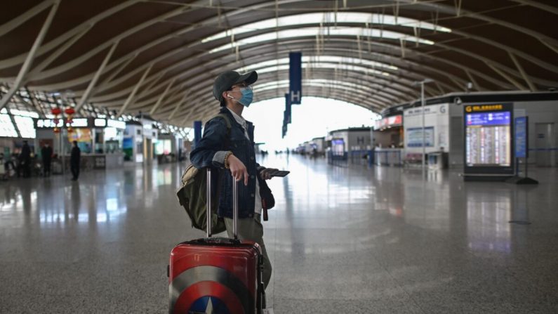 Un pasajero mira una pantalla en el Aeropuerto Internacional de Shanghai Pudong en Shanghai, China, el 19 de marzo de 2020. (HECTOR RETAMAL/AFP a través de Getty Images)