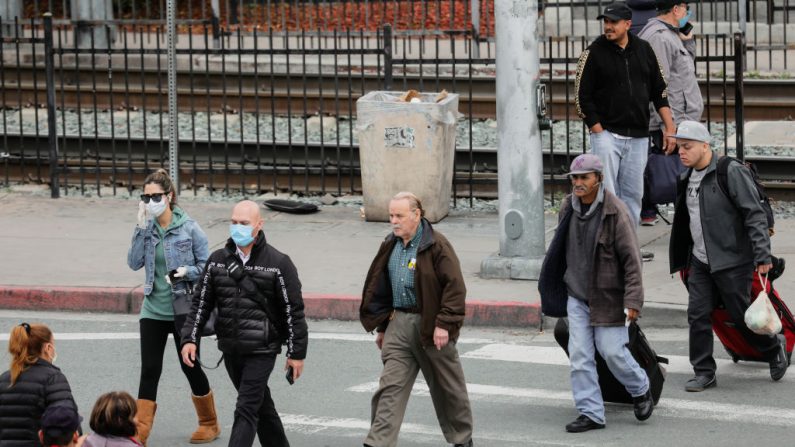 Los peatones cruzan la calle después de venir de México a lo largo de la frontera entre EE.UU. y México en San Ysidro, California, el 20 de marzo de 2020. (SANDY HUFFAKER/AFP vía Getty Images)