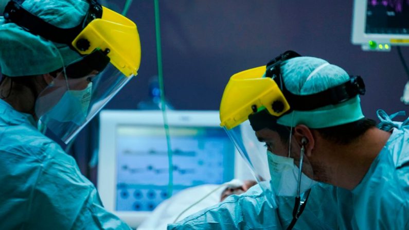 Trabajadores médicos con equipo de protección trabajan el 25 de marzo de 2020 en la unidad de cuidados intensivos para pacientes contaminados con el virus del PCCh.(Imagen de contexto de KENZO TRIBOUILLARD/AFP vía Getty Images)
