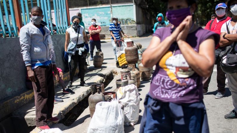 La gente hace cola hasta ocho horas para comprar un cilindro de gas butano durante la segunda semana de la cuarentena nacional el 27 de marzo de 2020 en Caracas, Venezuela. (Leonardo Fernández Viloria/Getty Images)