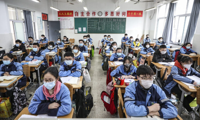 Los estudiantes de tercer grado en la escuela media y secundaria regresan a clases después de que la apertura del trimestre se retrasó debido al brote de virus del PCCh en Huaian, provincia de Jiangsu, China, el 30 de marzo de 2020. (STR/AFP vía Getty Images)