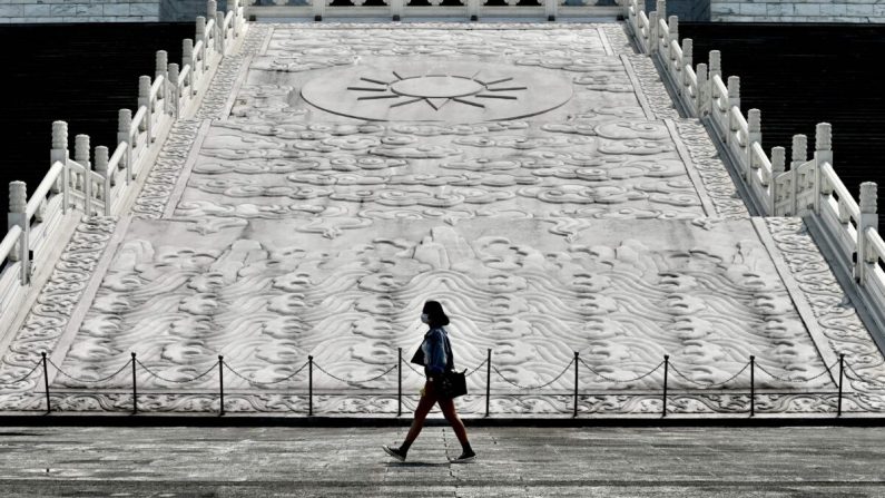 Una mujer con una máscara facial camina frente al Salón Conmemorativo de Chiang Kai-shek en Taipei, Taiwán, el 31 de marzo de 2020. (Sam Yeh/AFP a través de Getty Images)