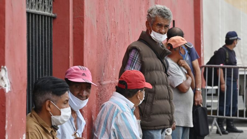 Los sin techo esperan al llegar a un refugio instalado en la bicentenaria Plaza de Toros de Acho en Lima (Perú) durante la pandemia de COVID-19, el 31 de marzo de 2020. (CRIS BOURONCLE/AFP vía Getty Images)