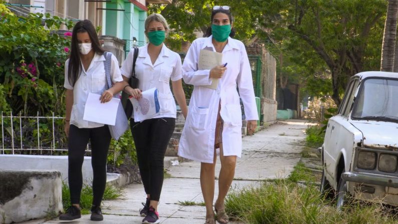 La doctora cubana Liz Caballero (d), del policlínico El Vedado en La Habana, Cuba, camina con dos estudiantes mientras van puerta por puerta buscando posibles casos del virus del PCCh, el 31 de marzo de 2020. (ADALBERTO ROQUE/AFP vía Getty Images)