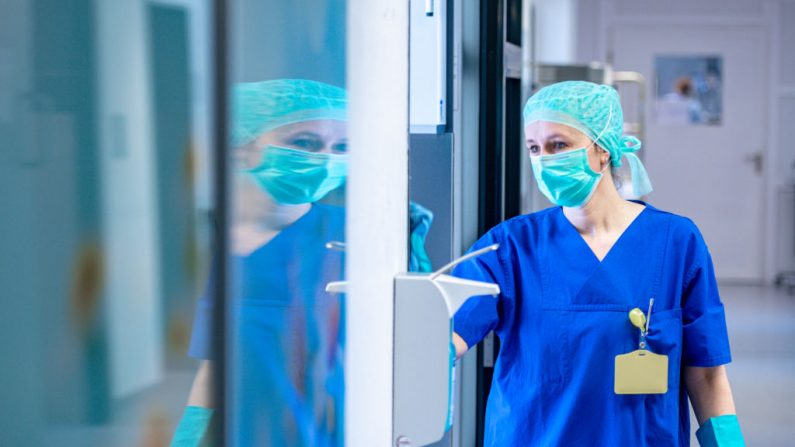 Una personal médica con una máscara y ropa protectora limpia partes de la unidad de cuidados intensivos del Hospital St. Josef el 1 de abril de 2020 en Bochum (Alemania). (Sascha Schuermann/Getty Images)