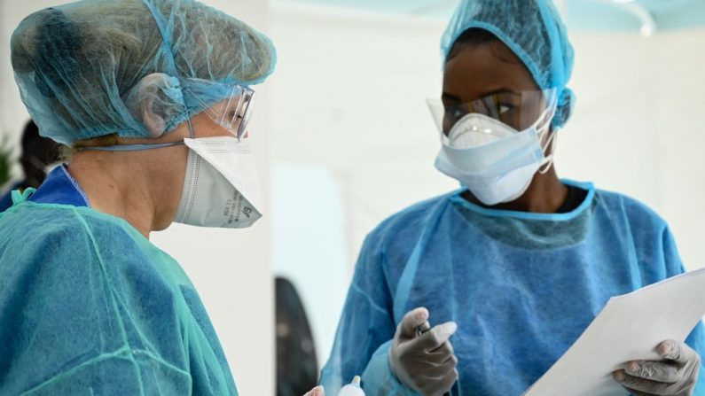 Miembros del personal médico, con mascarillas y trajes de protección, hablan juntos en un centro médico, en París, Francia, examinando a un paciente potencialmente contaminado por el virus del PCCh, el 1 de abril de 2020, durante un estricto cierre en Francia. (BERTRAND GUAY/AFP vía Getty Images)