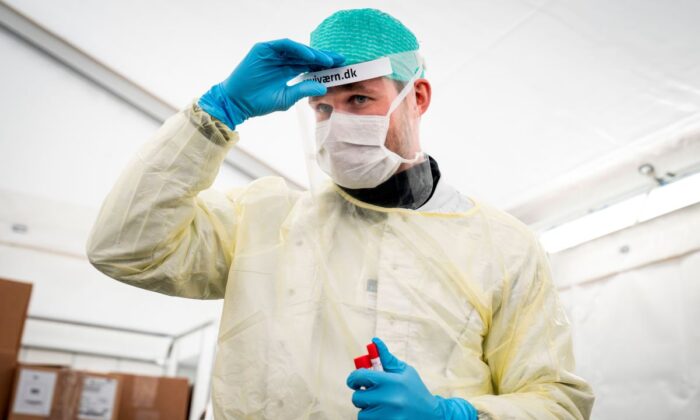 Un doctor se ajusta su visor antes de tomar una muestra bucal a un paciente para el test del Coronavirus Covid-19 en una extensión en carpa al Hospital Nacional Danés Rigshospitalet en Copenhagen, Dinamarca, el 2 de abril de 2020. (Niels Christian Vilmann/Ritzau Scanpix/AFP via Getty Images)