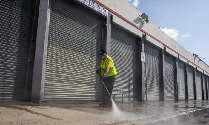 Personal de limpieza del distrito de moda de Los Ángeles desinfecta la vereda en el distrito de moda en el centro de Los Ángeles, California, el 2 de abril de 2020. (Apu Gomes/AFP via Getty Images)