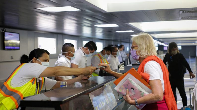 Una turista recibe su pasaporte para embarcar en un avión con destino a París, en el aeropuerto Augusto C. Sandino de Managua, Nicaragua, el 3 de abril de 2020. (Maynor Valenzuela/AFP vía Getty Images)