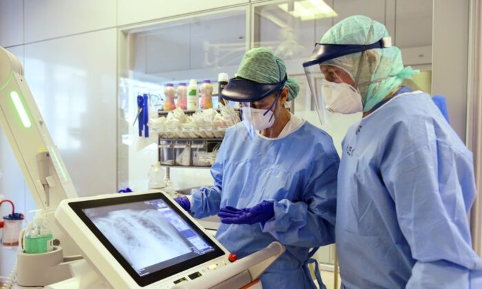 El personal médico observa el escáner de los pulmones de un paciente en una Unidad de Cuidados Intensivos (UCI) que acoge a los pacientes de COVID-19  el 3 de abril de 2020. (Piero Cruciatti/AFP vía Getty Images)