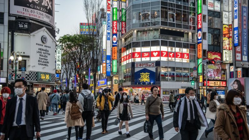 La gente cruza una carretera cerca del distrito de entretenimiento para adultos Kabuki-cho de Tokio, un área que ha visto un número desproporcionado de casos del virus del PCCh, el 6 de abril de 2020 en Tokio, Japón. (Carl Court/Getty Images)
