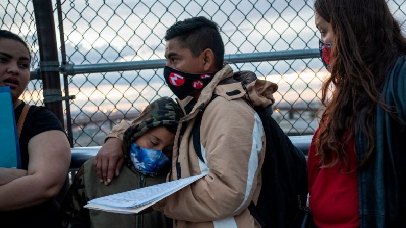 César, 35, un solicitante de asilo de Nicaragua espera con su esposa, Carolina, 25, (derecha) y su hijo Donovan de ocho años entrar en el puerto de entrada de EE.UU. para cambiar sus fechas de corte de asilo el 6 de abril de 2020 en el Puente Internacional Paso del Norte en Ciudad Juárez en el estado de Chihuahua, México. (Foto de PAUL RATJE/Agencia France-Presse/AFP vía Getty Images)
