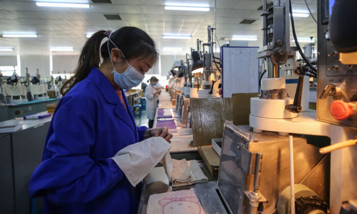 Una trabajadora en una línea de producción fotoeléctrica en una fábrica en Wuhan, China, el 6 de abril de 2020. (STR / AFP a través de Getty Images)