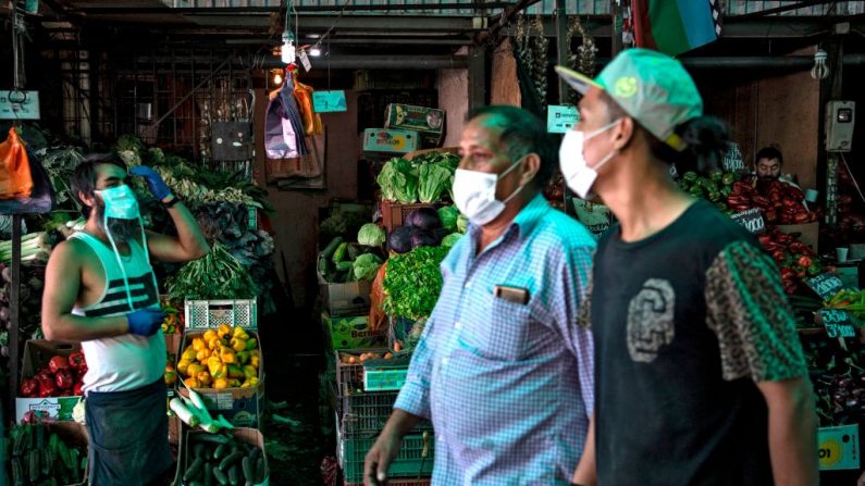 La gente usa máscaras faciales en el mercado central de Santiago, Chile, el 07 de abril de 2020, en medio de la nueva pandemia del virus del PCCh. (MARTIN BERNETTI/AFP vía Getty Images)