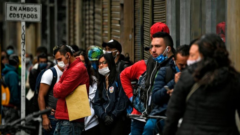La gente usa máscaras faciales como medida preventiva contra la propagación del virus del PCCh en una calle de Bogotá, el 7 de abril de 2020. (JUAN BARRETO/AFP vía Getty Images)