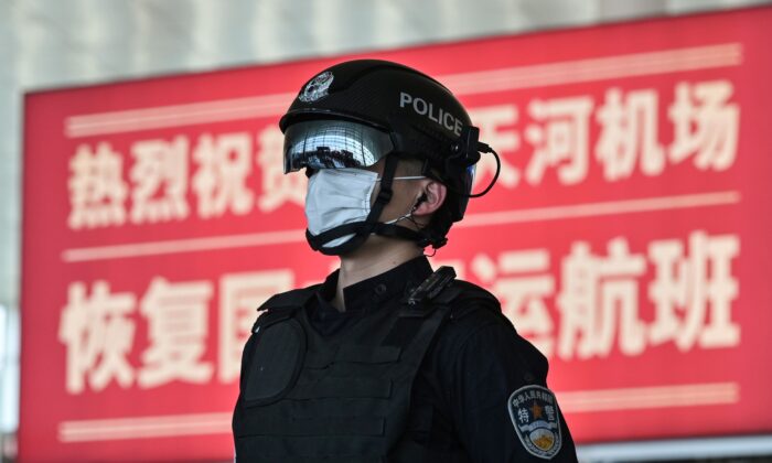 Un oficial de policía con una máscara facial hace guardia en el aeropuerto de Tianhe después de que se reabriera, en Wuhan, en la provincia central de China, Hubei, el 8 de abril de 2020. (Hector Retamal/AFP a través de Getty Images)