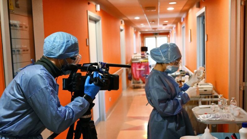 Un periodista filma a una enfermera en la unidad de cuidados intensivos COVID-19 en un hospital cerca de Roma, Italia, el 8 de abril de 2020. (Alberto Pizzoli/AFP/Getty Images)
