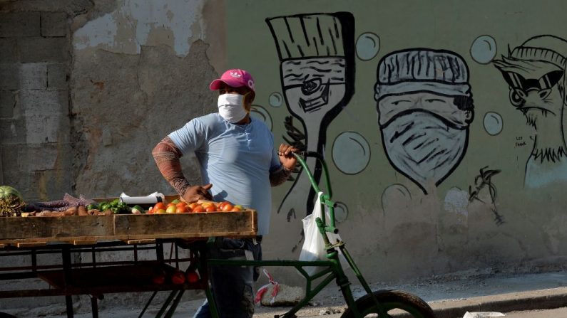 Un vendedor de frutas y verduras usa una máscara facial en La Habana, Cuba, el 11 de abril de 2020 en medio de la nueva pandemia del virus del PCCh. (YAMIL LAGE/AFP vía Getty Images)