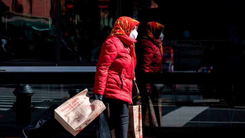 Una mujer lleva sus comestibles el 11 de abril de 2020, en la ciudad de Nueva York, EE.UU. (JOHANNES EISELE/AFP vía Getty Images)