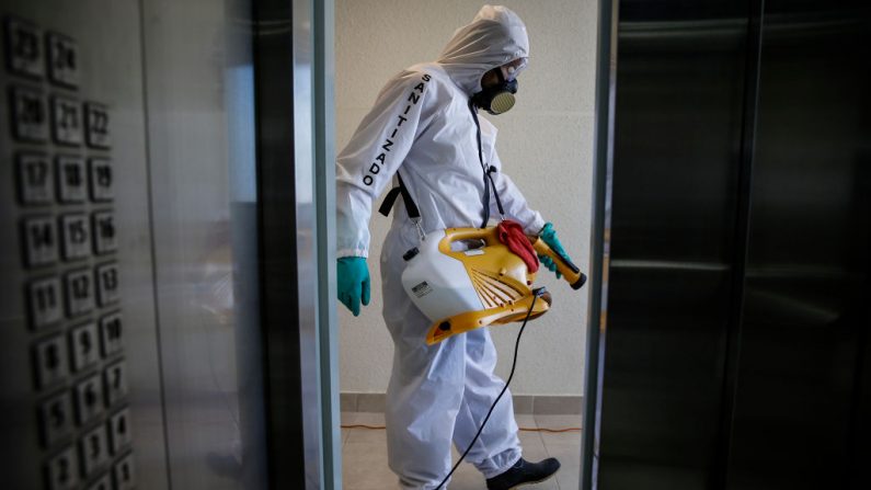 Un trabajador de saneamiento desinfecta un edificio de la comunidad como medida preventiva contra la propagación del virus del PCCh en Santiago, Chile, el 13 de abril de 2020. (JAVIER TORRES/AFP vía Getty Images)