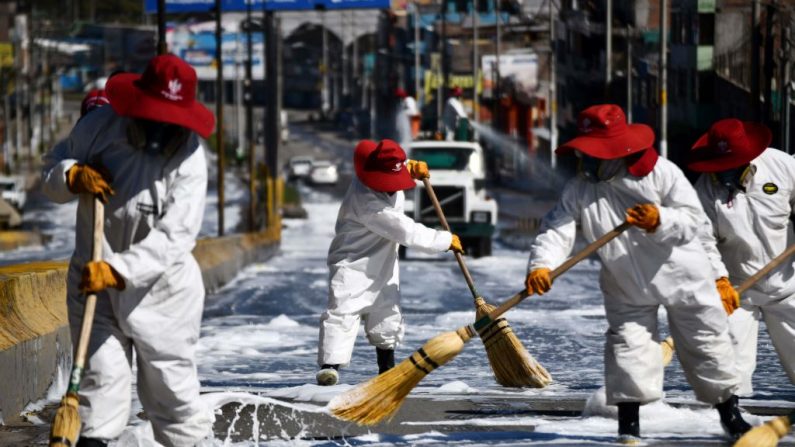 Trabajadores municipales de la ciudad sureña de Arequipa, la segunda ciudad más grande del Perú, friegan las calles que rodean un mercado el 15 de abril de 2020, una prevención sanitaria para luchar contra la propagación de covid-19. (DIEGO RAMOS/AFP vía Getty Images)
