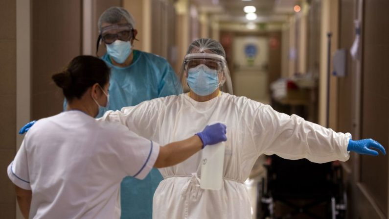 Un trabajador de la salud es desinfectado después de atender a pacientes con COVID-19 en la clínica privada CEMTRO en Madrid (España) el 17 de abril de 2020. (PIERRE-PHILIPPE MARCOU/AFP vía Getty Images)