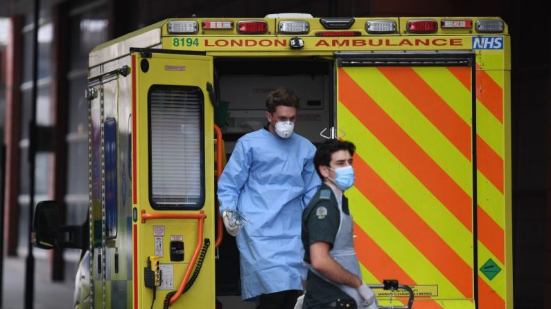 Los paramédicos que usan equipo de protección personal (PPE) ayudan a un paciente de una ambulancia al Hospital Real de Londres en el este de Londres, Inglaterra, el 18 de abril de 2020. (DANIEL LEAL-OLIVAS/AFP vía Getty Images)