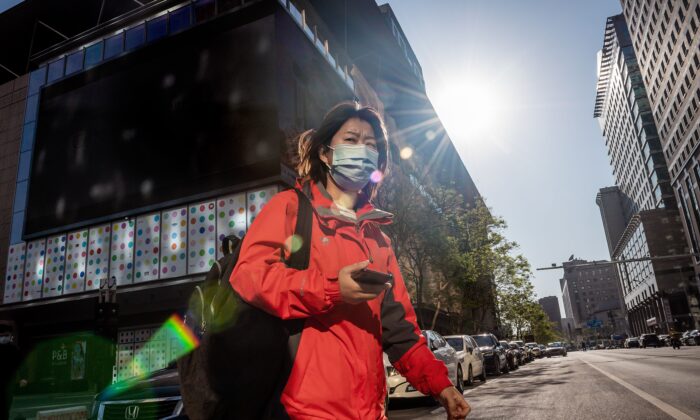 Una mujer con una mascarilla cruza una calle en Beijing el 22 de abril de 2020. (Nicolas Asfouri/AFP vía Getty Images)