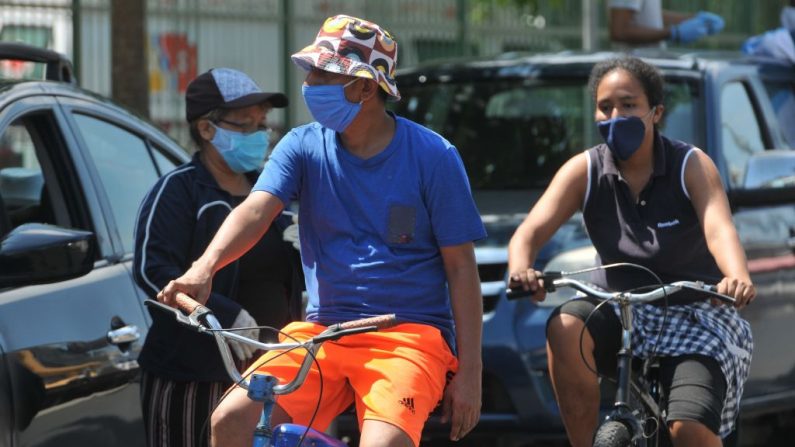 La gente va en bicicleta con máscaras faciales en Guayaquil, Ecuador, el 25 de abril de 2020. (JOSE SANCHEZ LINDAO/AFP vía Getty Images)