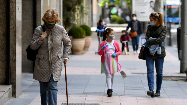 Las personas que llevan máscaras faciales caminan en Madrid (España) el 30 de abril de 2020 durante un encierro nacional para prevenir la propagación de la enfermedad COVID-19. (GABRIEL BOUYS/AFP vía Getty Images)