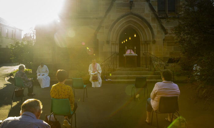 El padre James Collins celebra un servicio en el patio de la iglesia anglicana de San Pablo en Burwood con asientos que observan el distanciamiento social el 22 de marzo de 2020 en Sydney, Australia. (Jenny Evans/Getty Images)