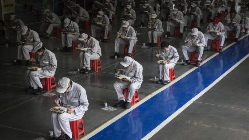 Los empleados almuerzan mientras permanecen a 2 metros de distancia en la planta de Dongfeng Fengshen en Wuhan, provincia de Hubei, China, el 24 de marzo de 2020. (Getty Images)