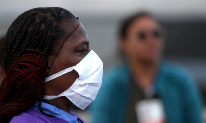 Doctores, enfermeras y trabajadores del Sistema de Salud Alameda usan equipo de protección individual durante una protesta pidiendo mejores condiciones de trabajo y EPI frente al Hospital Highland en Oakland, California, el 26 de marzo de 2020. (Justin Sullivan/Getty Images)