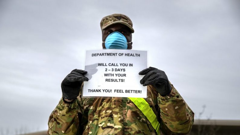 Un soldado de la Guardia Nacional de EE.UU. informa a distancia a los pacientes en un centro de pruebas de virus del PCCH en el Lehman College en el Bronx, Nueva York, el 28 de marzo de 2020. (John Moore/Getty Images)