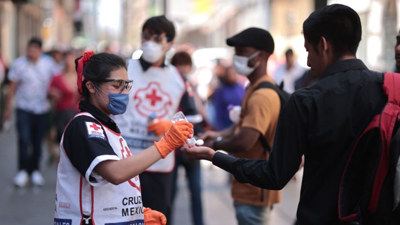 Personal de la Cruz Roja le da gel antibacterial a un hombre el 31 de marzo de 2020 en la Ciudad de México, México. (Hector Vivas/Getty Images)
