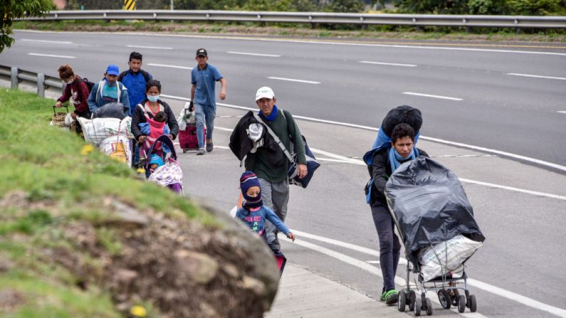 Migrantes venezolanos caminan con sus pertenencias por la autopista el 07 de abril de 2020 en Bogotá, Colombia, dirigiéndose al paso fronterizo de Cúcuta, a 550 km de Bogotá. (Guillermo Legaria/Getty Images)