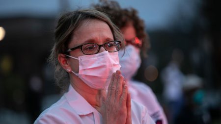 Enfermeras rezan por pacientes y familias en el helipuerto del hospital durante el brote de COVID-19