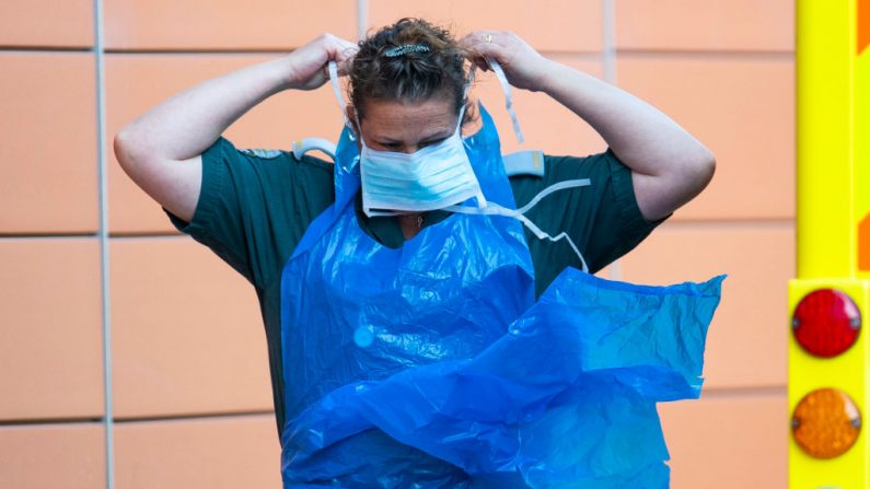 Una trabajadora de una ambulancia de Londres se pone una máscara protectora en el exterior del Royal London Hospital el 20 de abril de 2020 en Londres, Inglaterra. (Justin Setterfield/Getty Images)