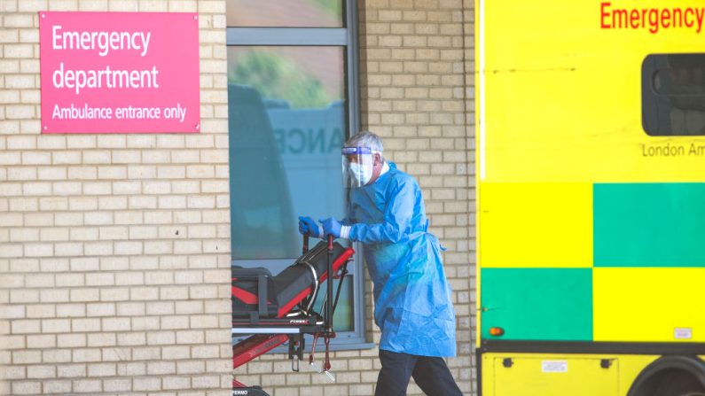 Un trabajador del Servicio Nacional de Salud en el EPP rueda un carrito de una ambulancia en el Hospital de Queens el 21 de abril de 2020 en Londres, Inglaterra. (Justin Setterfield/Getty Images)