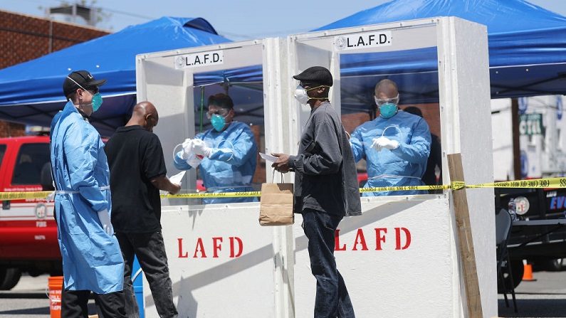 Los miembros del Departamento de Bomberos de Los Ángeles llevan a cabo la prueba COVID-19 en Skid Row 21 de abril de 2020 en Los Ángeles, California. (Mario Tama/Getty Images)