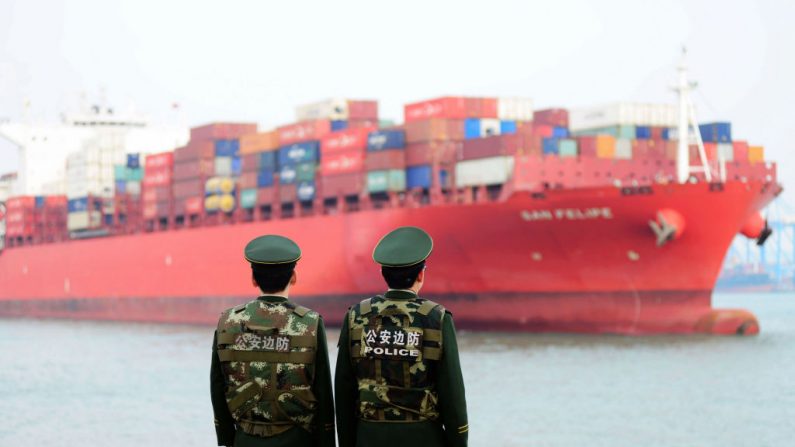 Oficiales de policía chinos vigilan un buque de carga en un puerto de Qingdao en la provincia oriental de Shandong de China el 8 de marzo de 2018. (AFP vía Getty Images)