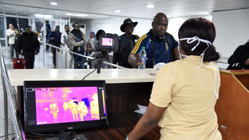 Un miembro del personal del Servicio de Salud Portuaria junto a un escáner térmico mientras los pasajeros llegan al Aeropuerto Internacional Murtala Mohammed en Lagos, Nigeria, el 27 de enero de 2019. (PIUS UTOMI EKPEI/AFP a través de Getty Images)