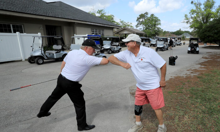 Dos golfistas chocan el codo en el Club de Golf Windsor Parke en Jacksonville Beach, Florida, el 25 de marzo de 2020. (Sam Greenwood/Getty Images)