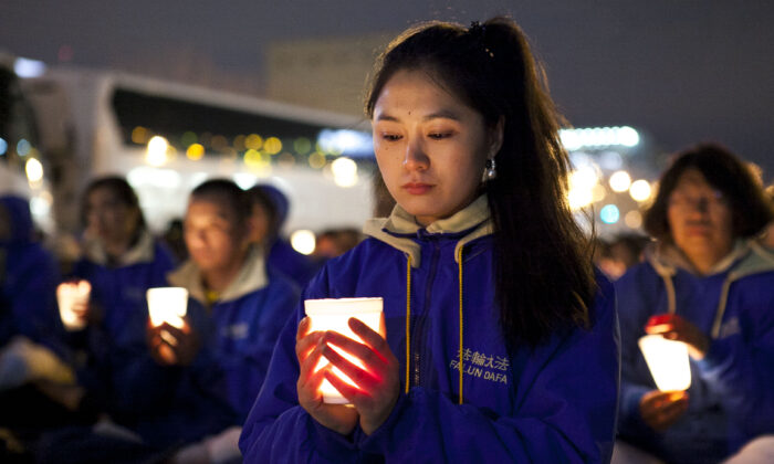 Los practicantes de Falun Dafa celebran una vigilia a la luz de las velas como una protesta pacífica cerca del Consulado de China en Nueva York el 25 de abril de 2014, para conmemorar el aniversario de la protesta pacífica a gran escala del 24 de abril de 1999 en Beijing. (Samira Bouaou/Epoch Times)