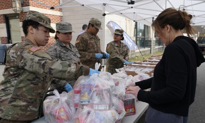 Soldados de la Guardia Nacional dan comida a los residentes de New Rochelle en el Condado de Westchester, N.Y., el 12 de marzo de 2020. (Timothy A. Clary/AFP vía Getty Images)