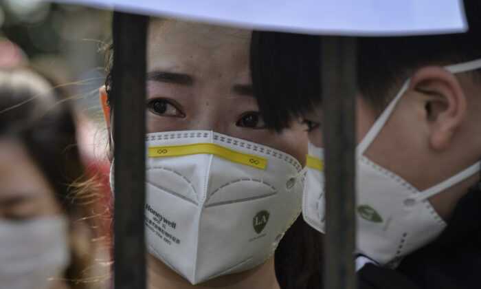 Un residente de Wuhan muestra su angustia cuando un equipo de asistencia médica, de la provincia de Yunnan, abandona la ciudad de Wuhan, el 18 de marzo de 2020. (AFP a través de Getty Images)
 
